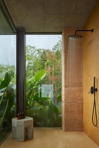 a bathroom with a shower and a large window at ACHIOTÉ Architectural Gem - Adults Only in Uvita