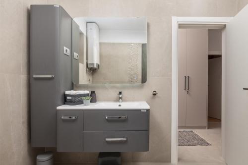 a bathroom with a sink and a mirror at APARTMAN UHAČ in Mošćenička Draga