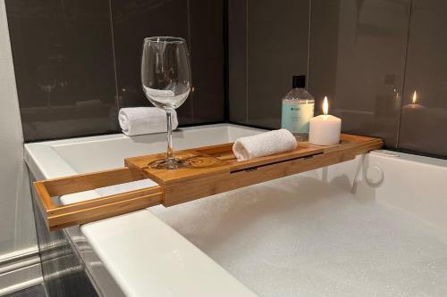 a candle and a wine glass sitting on a bath tub at Le Cozy Nest by Gestion ELITE in Mont-Tremblant