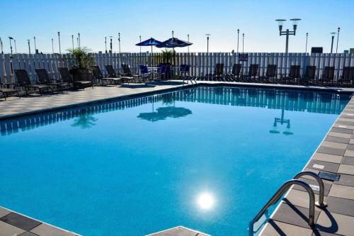 a large swimming pool with chairs and an umbrella at Berkeley Oceanfront Hotel in Asbury Park