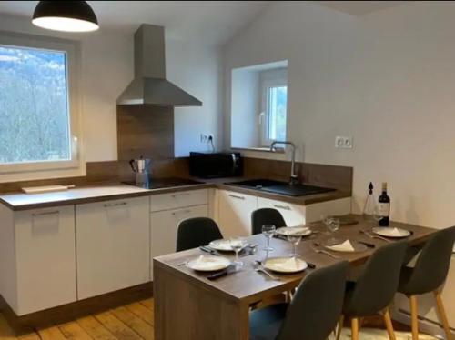une cuisine avec une table et des chaises ainsi qu'une salle à manger dans l'établissement Le Chalet - Appartement 5 personnes avec parking, à Savignac-les-Ormeaux