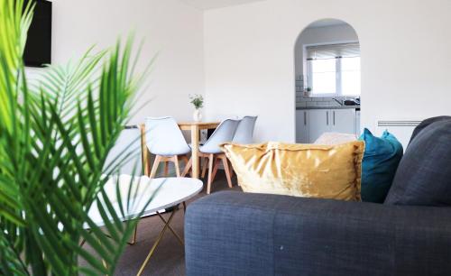 a living room with a blue couch and a table at Flat in London- Modern 2 Bedroom Apartment Harrow near Wembley in Harrow