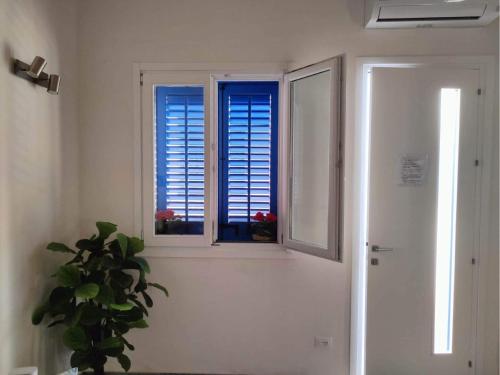 una habitación con una ventana y una planta al lado de una puerta en Il Rifugio en Marettimo