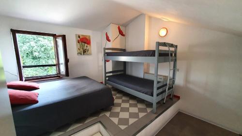 シルミオーネにあるAppartamenti Adriana Sirmioneのベッドルーム1室(二段ベッド2台、窓付)が備わります。