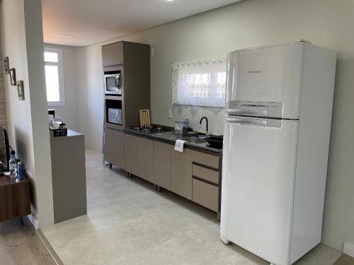 a kitchen with a white refrigerator in a room at Aconchego na Serra - Nova Petrópolis in Nova Petrópolis