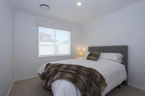 a bedroom with a large bed with a large window at Papamoa Coastal Luxury in Papamoa