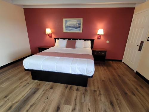 a bedroom with a large bed and red walls at Espana Motel in Norwalk
