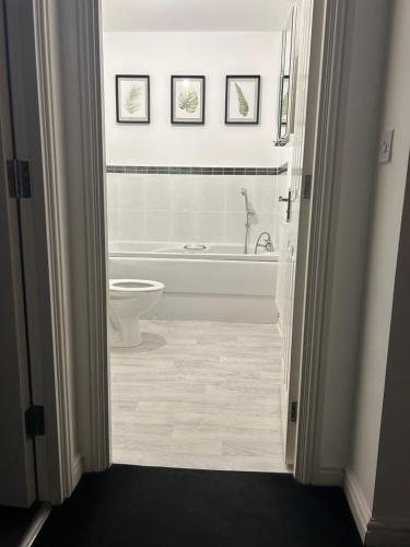baño blanco con bañera y aseo en Entire 3 bedroom deluxe house en Cleckheaton