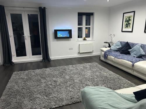 uma sala de estar com um sofá e um tapete em Entire 3 bedroom deluxe house em Cleckheaton