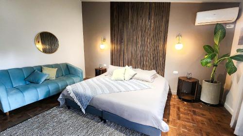 メデジンにあるLuxury Villa In Aguacatala2のベッドルーム(ベッド1台、青いソファ付)