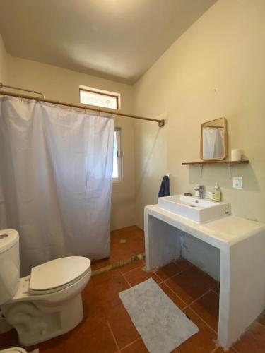 y baño con aseo blanco y lavamanos. en Beautiful 2 bedroom apartment, en Santa María Tonameca