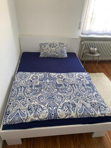 a bed with a blue and white comforter on it at Nisas Ferienwohnung in Bad Säckingen
