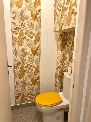 La salle de bains est pourvue de toilettes et d'un couvercle jaune. dans l'établissement Bel appartement lumineux et calme à 10min à pied du centre Aix avec parking et Air conditionné, à Aix-en-Provence