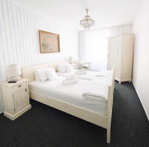 a bedroom with a white bed with white sheets and pillows at Penzion Jakub in Lanškroun