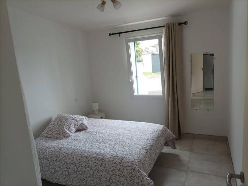 une chambre blanche avec un lit et une fenêtre dans l'établissement La Maisonnette aux volets bleus, à Bretignolles-sur-Mer