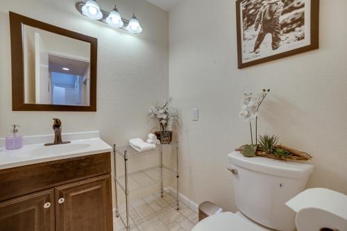 a bathroom with a toilet and a sink and a mirror at Reno Getaway with Spacious Patio and Grill! in Reno