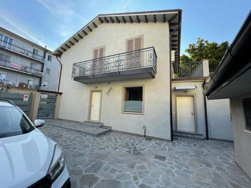 ein weißes Haus mit einem Balkon und einem Parkplatz in der Unterkunft Santa caterina in Crema