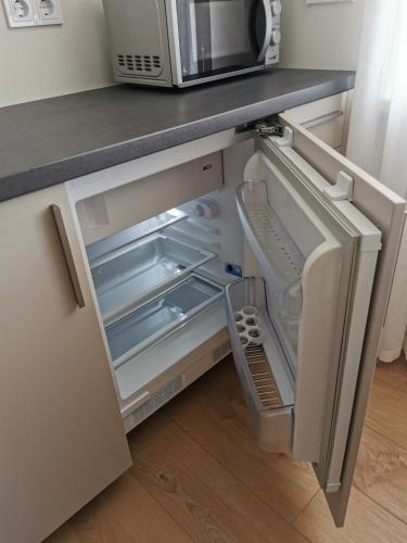 ツェーシスにあるCēsu apartamentiのキッチンにあるドアが開いた冷蔵庫