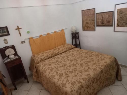 um quarto com uma cama e uma cruz na parede em La sartoria em Centuripe