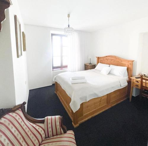 a bedroom with a large bed and a couch at Penzion Jakub in Lanškroun
