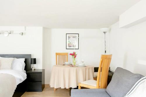 a bedroom with a table and a bed at Garden flat on leafy Cator Estate in Blackheath in London