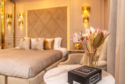 a bedroom with a bed and a table with a vase of flowers at Alexandras Palace in Bradford