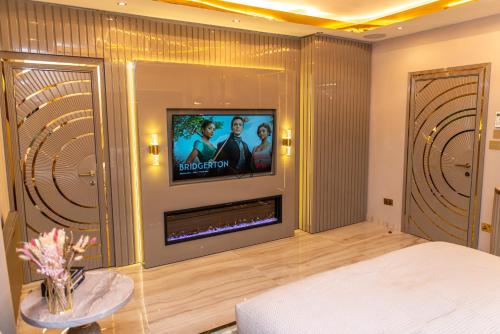 a living room with a fireplace and a tv at Alexandras Palace in Bradford