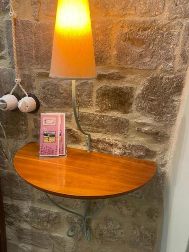 a table with a lamp and a telephone on it at La Lavandula in Poppi