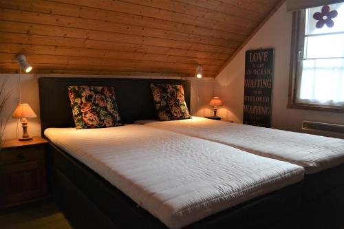 a large bed in a room with a wooden ceiling at Villa Rosenrot in Userin