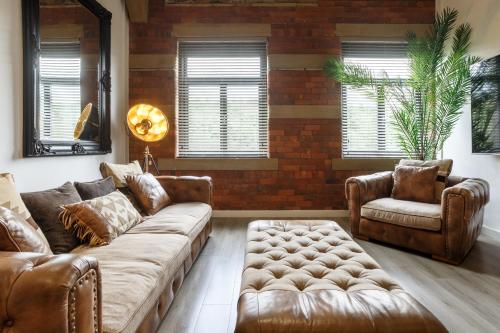 a living room with a couch and two chairs at Stunning Designer Penthouse - 85'' Cinema TV! in Bradford