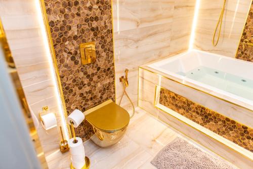 a bathroom with a tub and a toilet and a sink at Alexandras Palace in Bradford