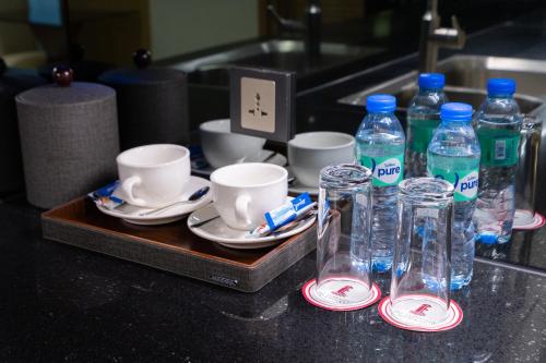 a tray with bottles of water and cups on a counter at One Euphoria Luxe Hotel in Angeles