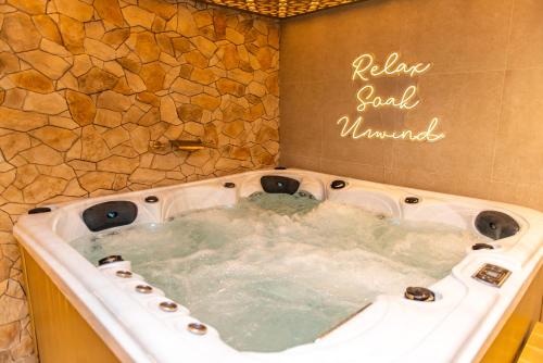 a hot tub in a bathroom with a stone wall at Alexandras Palace in Bradford