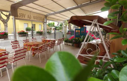 patio ze stołami i krzesłami oraz budynek w obiekcie Hotel La Vela w mieście Bellaria-Igea Marina