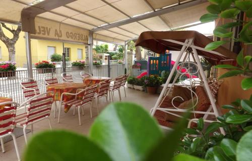 a patio with tables and chairs and a building at Hotel La Vela in Bellaria-Igea Marina