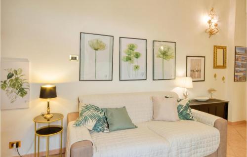 salon z białą kanapą z czterema obrazami na ścianie w obiekcie Lovely Apartment In Nervi With Wifi w Genui
