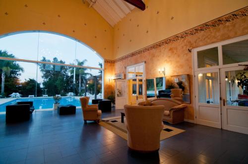 - un salon avec une grande fenêtre et une piscine dans l'établissement Solanas Termas de Dayman, à Termas del Daymán