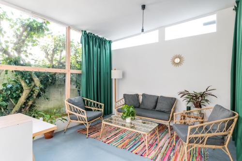 uma sala de estar com um sofá e cadeiras e uma janela em Casa Cabanas Ponta Delgada em São Roque