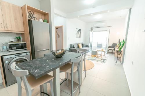 een keuken en een woonkamer met een tafel en stoelen bij City Apartment 58 - 5min to Kos Beach in Kos-stad