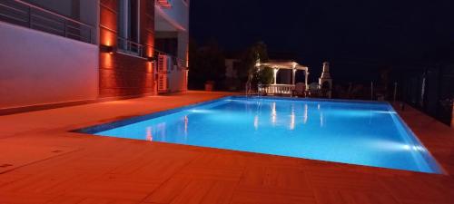 a large blue swimming pool at night at Azize in Fethiye