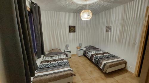 - 2 lits dans une chambre avec des rideaux dans l'établissement locations T2 et T3 entre Fréjus et Ste Maxime, au Muy