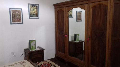 1 dormitorio con armario de madera y espejo en Habitación con Baño Privado en Casa del Zorzal en Tandil en Tandil