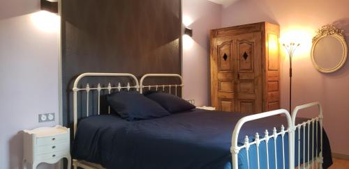 - une chambre avec un lit bleu et une armoire en bois dans l'établissement le gite d'Alice, à Vacqueyras