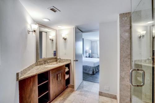 baño con lavabo, espejo y cama en Waterview Condo- Spacious 2 bedroom - Central - Steps to Beach, en Fort Lauderdale