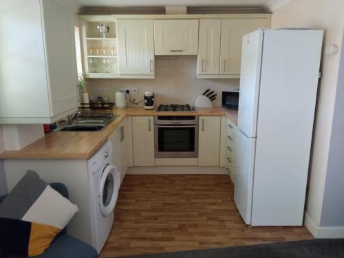 a kitchen with white appliances and a white refrigerator at Ground Floor Cornish Retreat Free Parking in Bodmin