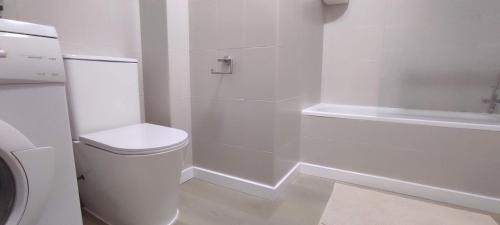biała łazienka z toaletą i prysznicem w obiekcie ZEUS BEACH Apartament w mieście Torrevieja