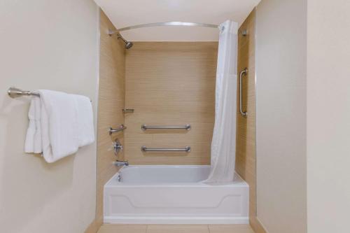 a white bath tub in a bathroom with a shower at Comfort Inn South Oceanfront in Nags Head