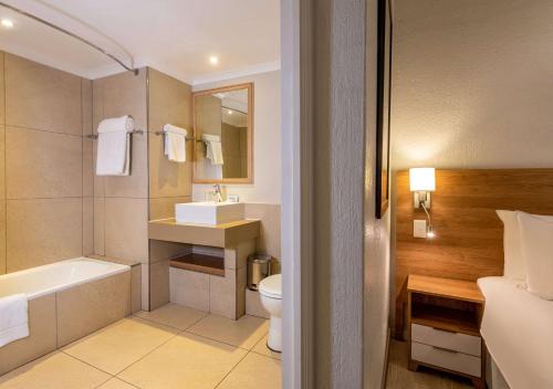 uma casa de banho com um WC, um lavatório e uma banheira em Pine Lake Resort em White River