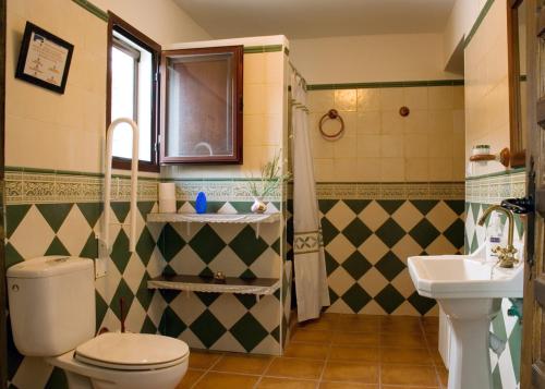a bathroom with a toilet and a sink at Cortijo Entresierras in Carcabuey