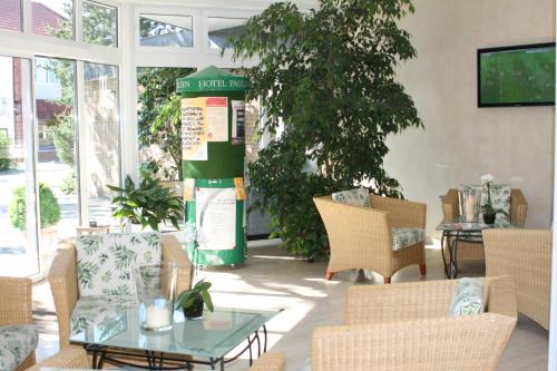 a living room with chairs and a table and a tree at Hotel Paulsen in Zeven
